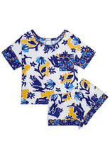 Load image into Gallery viewer, Flat lay. Matching Alex Pajama Set in the Alivia Whimsical Floral print which features scattered light and dark blue wildflowers with yellow shading on a white background. The classic men’s pajama style features a short sleeve boxy top with a scoop neckline, and loose-fitting shorts.