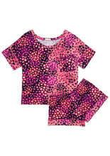 Load image into Gallery viewer, Flat lay. Matching Alex Pajama Set in Wild Cards Magenta with a snakeskin-like design. The left fabric panel of the shirt and right shirt sleeve cuff have a light pink background with fuchsia and hot pink and black clusters of colors in diamonds, hearts, spades, and clubs. The right fabric panel of the shirt and left shirt sleeve cuff have inverted colors, a black background with a design of light and dark pink playing card suits. The shorts are the darker fabric pattern with lighter leg bands. 