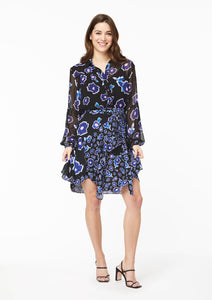 Front view. The Alivia Vicki Shirt in Poppy Play Black paired with the Gabi Skirt in Poppy Play Black and black strappy sandals. The shirt is tucked into the waistline of theskirt, creating the effect of a flowy dress with a cinched waist.