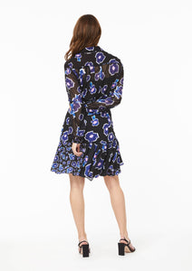 Back view. The Vicki Shirt paired with the Gabi Skirt, both in Poppy Play Black. The lined yoke and black camisole undershirt compliment the lined skirt, accentuating the sheer sections at the upper back and arms.