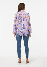 Load image into Gallery viewer, Back view of the Wildflower Burst Orchid Vicki Shirt. The shirt is paired with a white camisole top, appearing pale pink under the sheer pink fabric. Lighter distressed areas on the backpockets of the jeans create a more casual look.