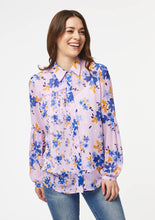 Load image into Gallery viewer, A person models the closeup front view of the Vicki Shirt in Wildflower Burst Orchid. The model’s arms are resting at their sides and the shirt is buttoned all the way to the top, creating a clean v-line at the base of the neck.